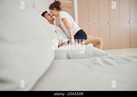 Frau in der Liebe sitzt auf ihrem Mann Schoß Stockfoto