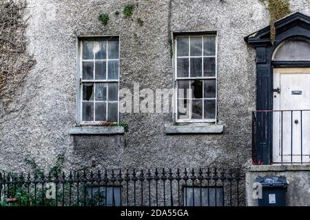 Chapelizod, Nahaufnahme eines verlassenen Hauses, das seine zerbrochenen Fenster zeigt, in Chapelizod, Dublin, Irland Stockfoto