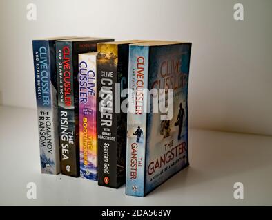 Norwich, Norfolk, Großbritannien – November 08 2020. Illustrative redaktionelle Foto einer Auswahl von Thriller Genre Taschenbuch Bücher von Clive Cussler isolat geschrieben Stockfoto