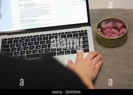 Offenes Tagebuch und Notebook, Gadgets für komfortables und effizientes Arbeiten an entfernten Standorten. Frau, die Text mit ihren Fingern auf der Tastatur in Google und ein Metall b Stockfoto