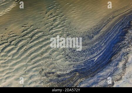 Ozeanwasser und Wellenmuster im Sand bei Ebbe. Stockfoto