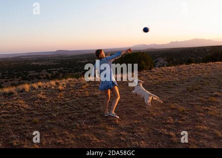 Teenager-Mädchen werfen Fußball bei Sonnenuntergang. Stockfoto