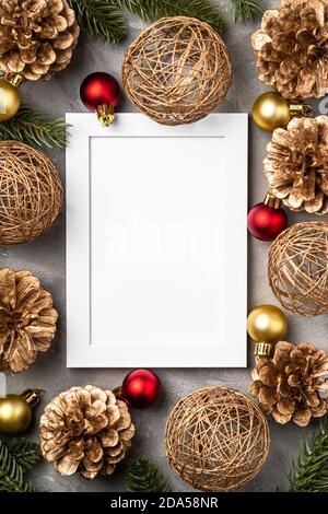 Weihnachtskomposition mit leerem Bilderrahmen. Goldenes Ornament, Tannenzapfen und Tannennadeln Dekorationen. Vorlage für Grußkarten Stockfoto