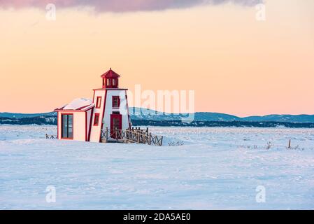 Winteransicht des kleinen Leuchtturms von Saint-Andre-de-Kamouraska mit Eis am Saint-Lawrence-Fluss, Quebec, Kanada Stockfoto