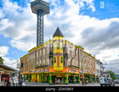 Die Gatlingburg Space Needle ragt über die Innenstadt von Gatlinburg, TN, mit Menschen, die Attraktionen genießen, wie Ripley's glauben, es ist whacky, bunt Stockfoto