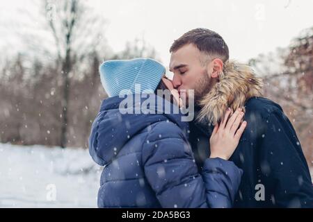 Freund und Freundin küssen im Freien zu Fuß und umarmt in verschneiten Winter Park. Romantisches Date Stockfoto