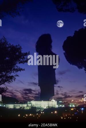 Silhouette einer Frau, die den Vollmond mit dem Palacio de Oriente in der Stadt Madrid, Hauptstadt Spaniens, Europa, betrachtet Stockfoto