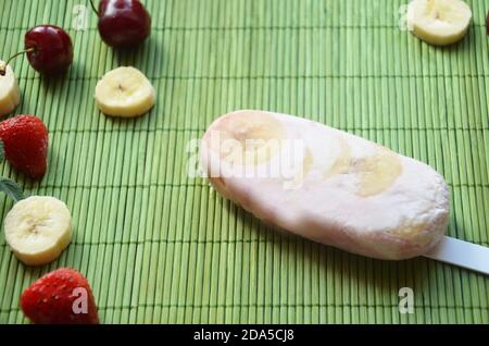 Hausgemachtes Erdbeer Kirsche Banane Heidelbeere Eis oder Eis Eis mit grünen Minze Blätter auf teal rustikalen Tisch, gefrorenen Fruchtsaft, Vintage-Stil dekoriert Stockfoto