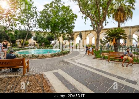 Touristen rund um den Brunnen an der Upper Barrakka Gardens, einem öffentlichen Garten in Valletta, Malta. Stockfoto
