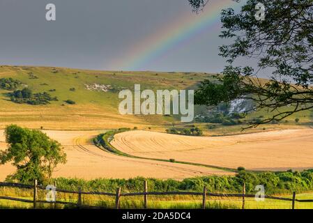 Ein Regenbogen erscheint über dem langen Mann von Wilmington nach einem kurzen schweren Regensturm an einem Sommerabend. Wilmington, East Sussex, England, Großbritannien. Stockfoto