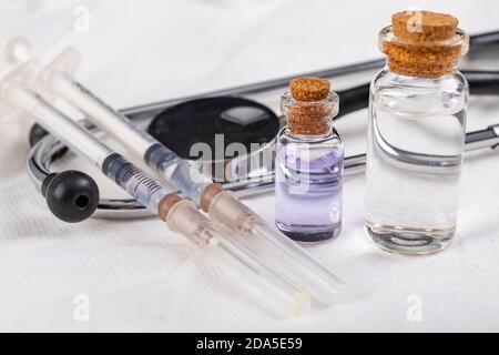 Basis-medizinische Ausrüstung für Impfungen vorbereitet. Schutzkleidung und medizinisches Zubehör. Heller Hintergrund. Stockfoto