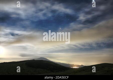 Wolken und Mond steigen am Sternenhimmel auf den Ätna, Sizilien Stockfoto