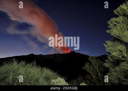 Rauch vom Vulkan Ätna während einer Eruption in der Nacht gegen Sternenhimmel, Sizilien Stockfoto