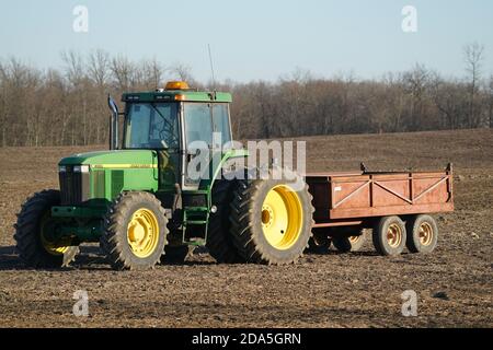 Traktor und Wagen auf geerntetem Feld Stockfoto