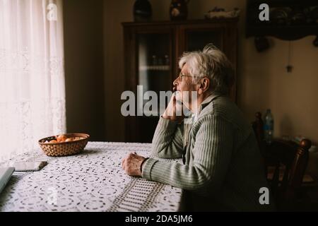 Seitenansicht einer älteren kaukasischen Frau, die am Telefon sprach Mit ihrer Familie während der Quarantäne COVID - 19 Coronavirus Stockfoto