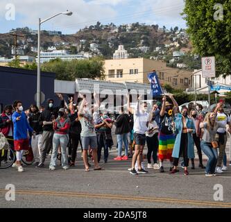 Menschenmassen versammeln sich, um die vorbeifahrende Autoparade zu beobachten, während die Menschen den Sieg von Joe Biden und Kamala Harris in West Hollywood, Kalifornien, feiern. Stockfoto