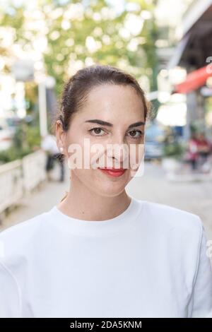 Porträt einer Frau mit updo Haar, lässig, natürlichen Look, schlank, im Freien, weiches Lächeln Stockfoto