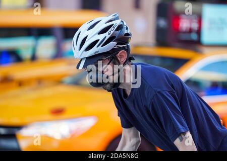 New York, USA. November 2020. Ein Mann mit Maske fährt mit dem Fahrrad am Times Square in New York, USA, 9. November 2020 vorbei. Die Gesamtzahl der COVID-19 Fälle in den Vereinigten Staaten erreichte am Montag einen düsteren Meilenstein von 10 Millionen, so das Center for Systems Science and Engineering (CSSE) an der Johns Hopkins University. US COVID-19 Fallzahl stieg auf 10,018,278, mit insgesamt 237,742 Todesfälle, ab 13:25 Uhr Ortszeit (1825 GMT), nach der CSSE-Zählung. Quelle: Wang Ying/Xinhua/Alamy Live News Stockfoto