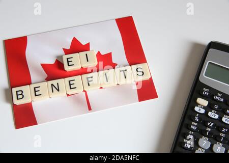 Arbeitsversicherung Konzeptioneller Titel. Draufsicht auf Connected Letters Game mit einer Kanadischen Flaggenkarte und einem Rechner im Hintergrund. Stockfoto