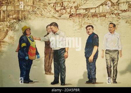 Ein Wandgemälde an der Ong Ang Walking Street von Klong Ong Ang, Chinatown / Phahurat, Bangkok, Thailand, zeigt Stadtbeamte, die einem Straßenräuter danken Stockfoto