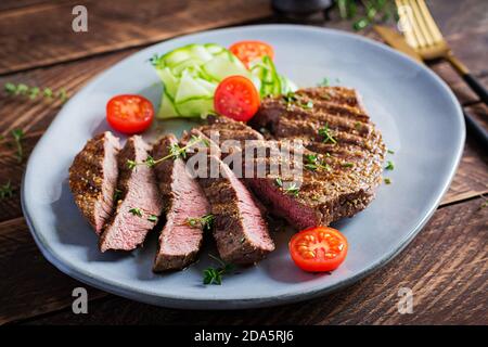 Gegrilltes saftiges Steak Medium rares Rindfleisch mit Gewürzen und frischem Salat. Stockfoto