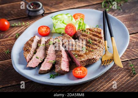 Gegrilltes saftiges Steak Medium rares Rindfleisch mit Gewürzen und frischem Salat. Stockfoto