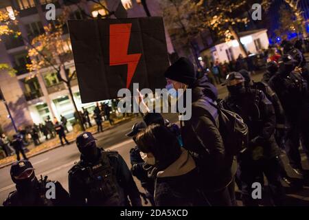 Ein Protestler mit Gesichtsmaske hält ein Plakat mit dem Symbol des Frauenwiderstands, dem roten Blitz während der Demonstration.die Gegner des Urteils des Verfassungsgerichts über Abtreibung protestierten erneut. Hunderte von Menschen versammelten sich vor dem Ministerium für Bildung, um den Rücktritt des Ministers für Bildung und Wissenschaft, Przemyslaw Czarnek, zu fordern, der für seine homophoben und chauvinistischen öffentlichen Äußerungen bekannt ist. Bei mehreren Gelegenheiten zerstreute die Polizei gewaltsam Demonstranten, die versucht hatten, den Verkehr zu blockieren und unerwartet durch das Stadtzentrum marschierten. Zahlreich Stockfoto