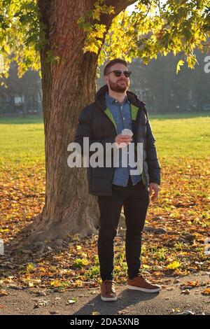 Porträt eines schönen jungen Mannes im Park - Herbstlandschaft Stockfoto