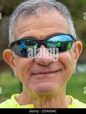 Radsportler mit Sonnenbrillen, die andere Radfahrer und ihre Fahrräder reflektieren Stockfoto