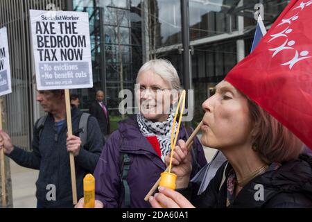 Protest zum ersten Jahrestag der "Bedroom Tax" vor dem Hyde Park, einer der teuersten Wohnheime Londons. Das Wohlfahrtsreform-Gesetz 2012, das am 1. April 2013 in Kraft trat, beinhaltete Änderungen der Wohngeld-Regeln. Diese Änderungen umfassen eine "Unterbelegung Strafe", die die Höhe der Leistung an Kläger gezahlt reduziert, wenn sie als zu viel Wohnraum in der Immobilie, die sie Anspruch Wohngeld auf haben, diese geändert wurde bekannt als die "Schlafzimmer Steuer". One Hyde Park, Knightsbridge, London, Großbritannien. April 2014 Stockfoto