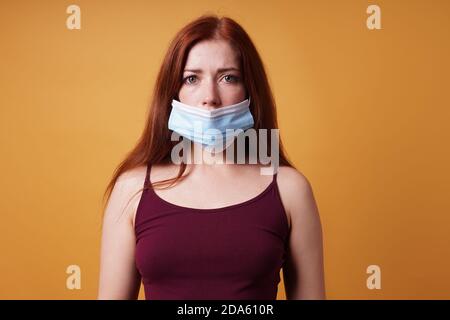 Junge Frau trägt medizinische Gesichtsmaske falsch verlassen Nase aufgedeckt - unsachgemäße Verwendung der schützenden Corona coronavirus covid Maske Stockfoto