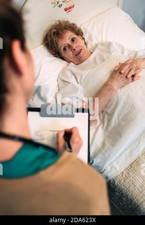 Ärztin Ausfüllen eines Fragebogens Stockfoto