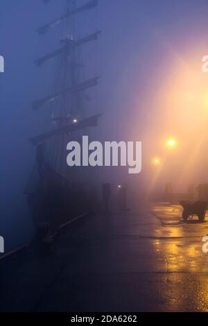 Hohes Schiff im nebligen Hafen in der Nacht im schottischen Hafen Von Stromness Stockfoto