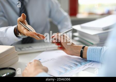 Weibliche und männliche Hände halten Stifte und bilden einen Geschäftsplan. Stockfoto