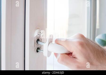 Der Fenstergriff ist kaputt. Halten Sie den Mechanismus in der Hand. Stockfoto