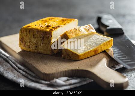 Würfel marinierter Tofu auf Schneidebrett. Stockfoto