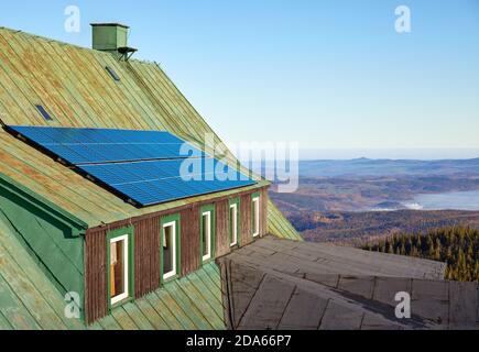 Sonnenkollektoren auf einem Dach einer alten Berghütte. Stockfoto