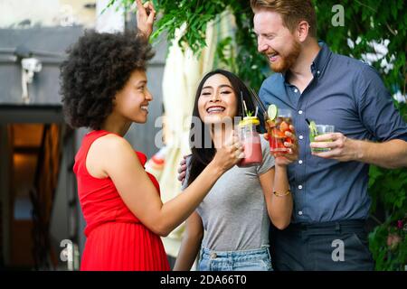 Freunde, die eine tolle Zeit im Café, lächeln und trinken Cocktails genießen zusammen. Stockfoto