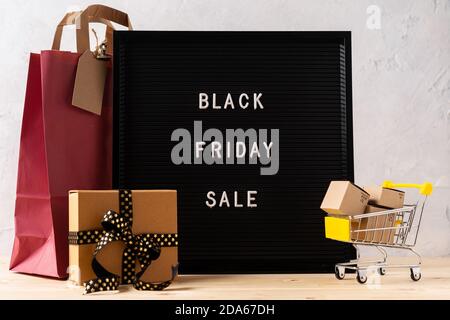 Text Schwarzer freitag auf schwarzem Briefbrett, Geschenk, Warenkorb, Tasche und Geschenkbox. Verkaufszeit der Konzeptsaison. Stockfoto