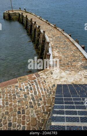 Wellenbrecher und Hafenmauer aus rotem Granit Stockfoto