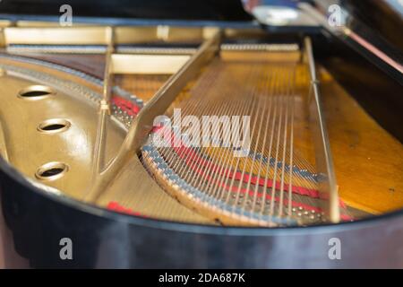 Innenansicht einer klassischen und goldenen Klaviersaiten von oben gesehen. Stockfoto