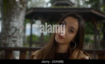 Portrait of Charming hübsche Frau sitzt im Pavillon, Blick auf die Kamera und sie sehen aus wie traurig und unglücklich, Lifestyle-Konzept Stockfoto