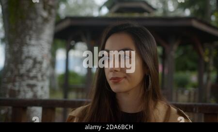 Portrait of Charming hübsche Frau sitzt im Pavillon, Blick auf die Kamera und sie sehen aus wie traurig und unglücklich, Lifestyle-Konzept Stockfoto