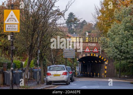 Lower Downs Road, Wimbledon, London, Großbritannien. 10. November 2020. Ein Network Rail Bericht zeigt diese Wimbledon Eisenbahnbrücke als eine der „am meisten gehetzten“ in London, kommt in der 2. Und schlug 11 mal in 2019-20. Es ist auch 10. Gleich am meisten in Großbritannien Bashed. Über dieser schmalen Bogenbrücke befinden sich vier Gleise, zwei für Pendlerzüge und zwei für Expresszüge von und nach London Waterloo im Südwesten Englands. Die Niederbrückenbrüstungsschild ist teilweise durch Baumbelaub auf dem südlichen Ansatz verdeckt. Quelle: Malcolm Park/Alamy Live News. Stockfoto