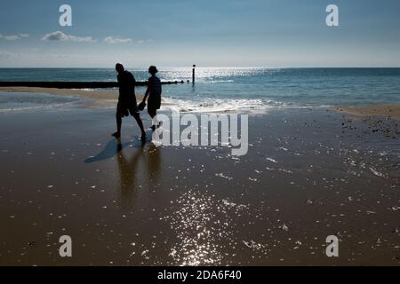 Ein Schattenspaziergang im Wasser bei Ebbe am Strand von Boscombe, einem Teil des berühmten 7 Meilen langen Sandstrandes in Poole und Bournemouth, Dorset. 21. September 2014. Foto: Neil Turner Stockfoto