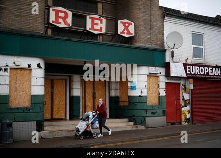 Coalville, Leicestershire, Großbritannien. November 2020. Eine Frau geht an einem ehemaligen Rex-Kino vorbei, nachdem die Arbeitslosenquote in Großbritannien gestiegen ist, da das Coronavirus weiterhin auf dem Arbeitsmarkt auftritt. Credit Darren Staples/Alamy Live News. Stockfoto