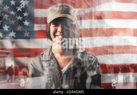 Feier in den USA. Porträt einer lächelnden Soldatinnen, die vor dem Hintergrund der amerikanischen Flagge posiert. Doppelbelichtung. Stockfoto