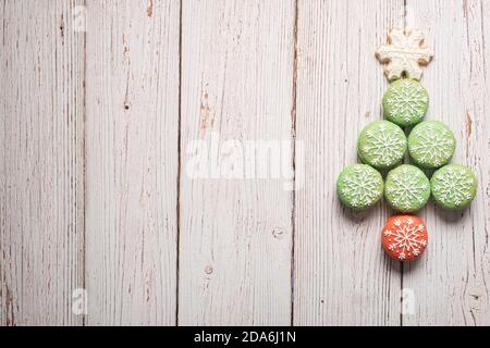 Weihnachtsbaum aus verzierten Makronen Makronen auf einer strukturierten Holzhintergrund mit Kopierraum und Platz für Text Stockfoto