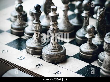 Altes abgenutztes Schachspiel auf einem Schachbrett. Ein schwieriges Schachspiel. Rivalität. Stockfoto