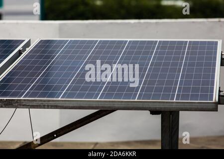 Nahaufnahme von solarbetriebenen Energiekollektoren auf einem Dach, um die Energie aus dem Sonnenlicht zu nutzen und Energie an Haushalte zu verteilen. Stockfoto